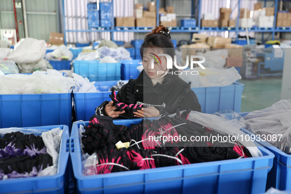 A worker is producing protective equipment for export in Lianyungang, China, on January 22, 2024. 