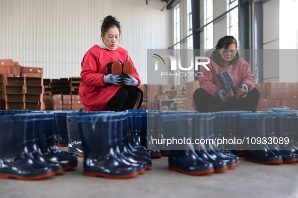 Two workers are producing protective equipment for export at a company in Lianyungang, East China's Jiangsu province, on January 22, 2024. 