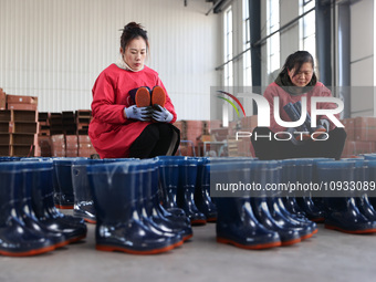 Two workers are producing protective equipment for export at a company in Lianyungang, East China's Jiangsu province, on January 22, 2024. (