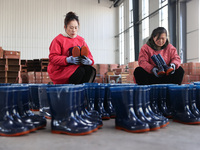 Two workers are producing protective equipment for export at a company in Lianyungang, East China's Jiangsu province, on January 22, 2024. (