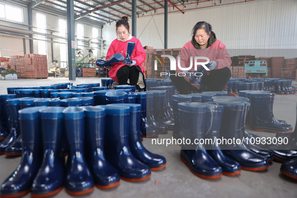 Two workers are producing protective equipment for export at a company in Lianyungang, East China's Jiangsu province, on January 22, 2024. 