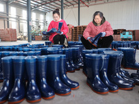 Two workers are producing protective equipment for export at a company in Lianyungang, East China's Jiangsu province, on January 22, 2024. (