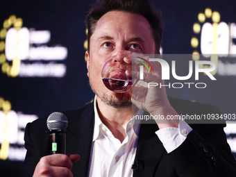 Elon Musk, owner of Tesla and the X (formerly Twitter) platform, is drinking water while attending a symposium on fighting antisemitism titl...