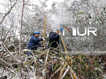 Workers are inspecting power supply lines in the cold mountainous area of Dongling village in Liuzhou, China, on January 23, 2024. (