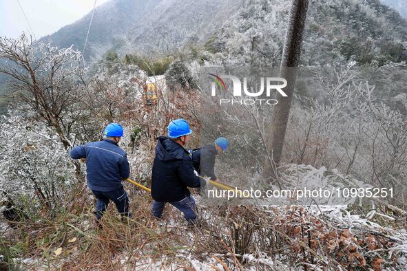 Workers are inspecting power supply lines in the cold mountainous area of Dongling village in Liuzhou, China, on January 23, 2024. 