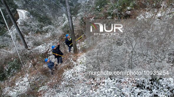 Workers are inspecting power supply lines in the cold mountainous area of Dongling village in Liuzhou, China, on January 23, 2024. 