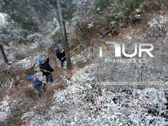 Workers are inspecting power supply lines in the cold mountainous area of Dongling village in Liuzhou, China, on January 23, 2024. (