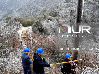 Workers are inspecting power supply lines in the cold mountainous area of Dongling village in Liuzhou, China, on January 23, 2024. (