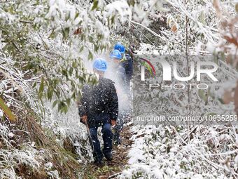 Workers are inspecting power supply lines in the cold mountainous area of Dongling village in Liuzhou, China, on January 23, 2024. (