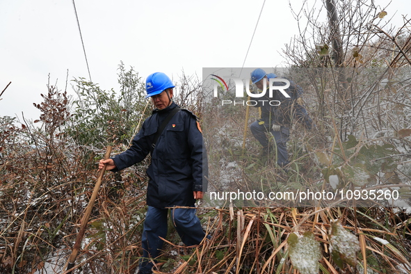 Workers are inspecting power supply lines in the cold mountainous area of Dongling village in Liuzhou, China, on January 23, 2024. 