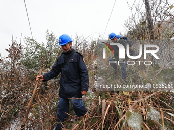 Workers are inspecting power supply lines in the cold mountainous area of Dongling village in Liuzhou, China, on January 23, 2024. (