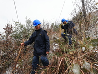 Workers are inspecting power supply lines in the cold mountainous area of Dongling village in Liuzhou, China, on January 23, 2024. (