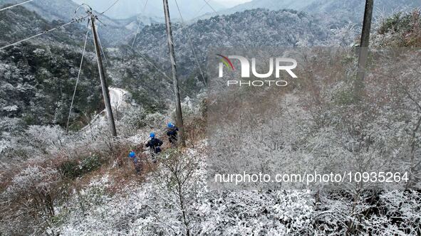 Workers are inspecting power supply lines in the cold mountainous area of Dongling village in Liuzhou, China, on January 23, 2024. 