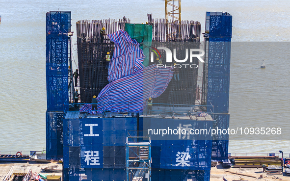 Workers are speeding up the construction of Taoyuan Bridge on the Beijing-Hangzhou Grand Canal in Suqian, East China's Jiangsu province, on...