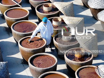 A worker at a soy sauce factory is checking the drying of sauces in a drying field in Lianyungang, China, on January 24, 2024. (