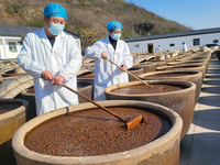 Workers are checking the drying of sauces in a drying field at a soy sauce factory in Lianyungang, Jiangsu Province, China, on January 24, 2...