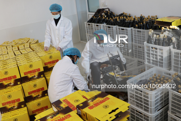 A worker is packing sauces at a soy sauce factory in Lianyungang, China, on January 24, 2024. 