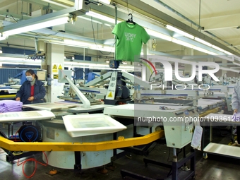 A worker is inspecting products at an automated knitwear assembly line in Nantong, Jiangsu province, China, on January 24, 2024. (