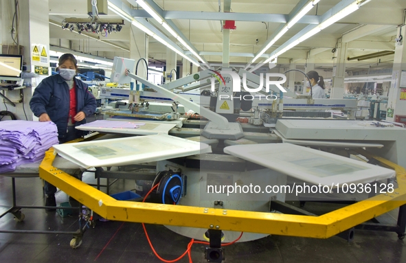 A worker is inspecting products at an automated knitwear assembly line in Nantong, Jiangsu province, China, on January 24, 2024. 