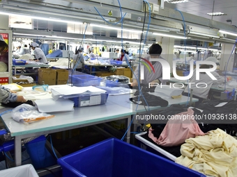 Workers are producing clothing products in Nantong, Jiangsu Province, China, on January 24, 2024. (