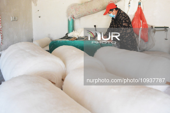 An employee is processing a cotton-padded quilt at a quilt processing shop in Anqing, China, on January 25, 2024. 