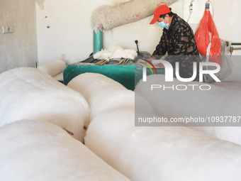 An employee is processing a cotton-padded quilt at a quilt processing shop in Anqing, China, on January 25, 2024. (