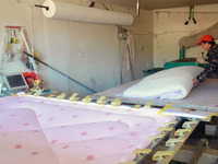 An employee is processing a cotton-padded quilt at a quilt processing shop in Anqing, China, on January 25, 2024. (