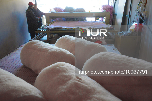 An employee is processing a cotton-padded quilt at a quilt processing shop in Anqing, China, on January 25, 2024. 