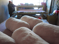 An employee is processing a cotton-padded quilt at a quilt processing shop in Anqing, China, on January 25, 2024. (