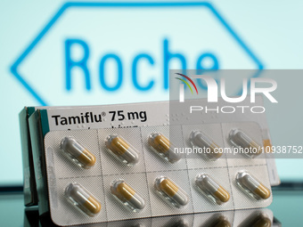 A box and a tablet of Tamiflu pills are being displayed with the Roche Pharmaceuticals logo in the background. (