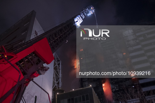 Firefighters are pumping water at the Gandhi Hotel Hospital in northern Tehran, Iran, on January 25, 2024, to control a fire. Patients are b...