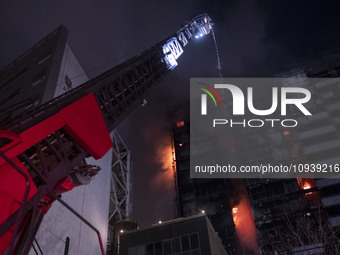 Firefighters are pumping water at the Gandhi Hotel Hospital in northern Tehran, Iran, on January 25, 2024, to control a fire. Patients are b...