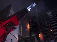 Firefighters are pumping water at the Gandhi Hotel Hospital in northern Tehran, Iran, on January 25, 2024, to control a fire. Patients are b...