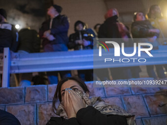 An Iranian woman is reacting while standing at the site of the fire at the Gandhi hotel hospital in northern Tehran, Iran, on January 25, 20...