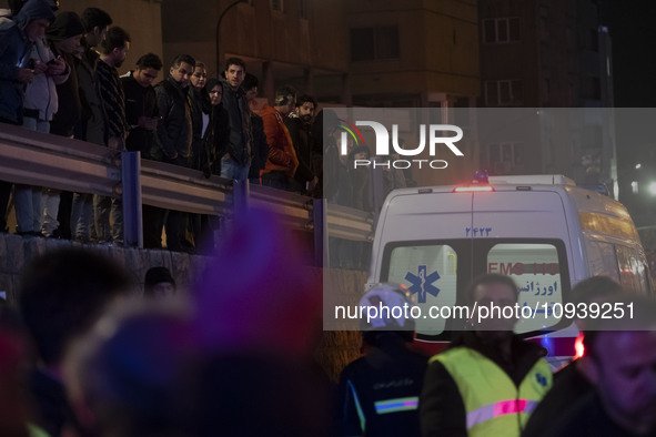 People are watching while standing at the site of the fire at the Gandhi hotel hospital in northern Tehran, Iran, on January 25, 2024. Patie...