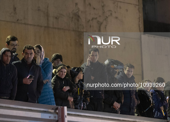 People are watching while standing at the site of the fire at the Gandhi hotel hospital in northern Tehran, Iran, on January 25, 2024. Patie...