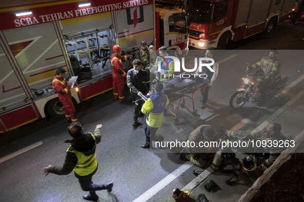 Iranian medical personnel are carrying a patient on a stretcher during a fire at the Gandhi hotel hospital in northern Tehran, Iran, on Janu...