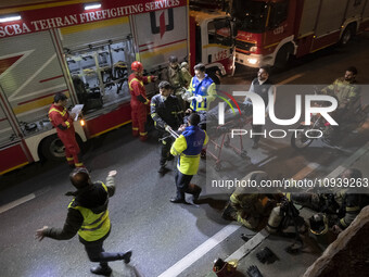 Iranian medical personnel are carrying a patient on a stretcher during a fire at the Gandhi hotel hospital in northern Tehran, Iran, on Janu...