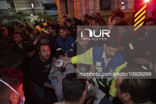 Iranian medical personnel are carrying a patient on a stretcher to an ambulance to transfer him to another hospital during a fire at the Gan...