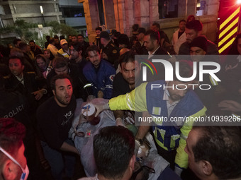 Iranian medical personnel are carrying a patient on a stretcher to an ambulance to transfer him to another hospital during a fire at the Gan...