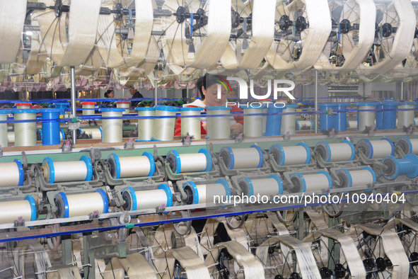 A worker is making silk products on a production line at a workshop of a silk production enterprise in Anqing, China, on January 26, 2024. 