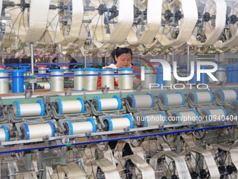 A worker is making silk products on a production line at a workshop of a silk production enterprise in Anqing, China, on January 26, 2024. (