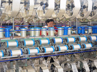 A worker is making silk products on a production line at a workshop of a silk production enterprise in Anqing, China, on January 26, 2024. (