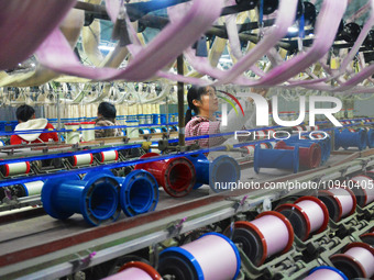 A worker is making silk products on a production line at a workshop of a silk production enterprise in Anqing, China, on January 26, 2024. (