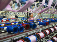 A worker is making silk products on a production line at a workshop of a silk production enterprise in Anqing, China, on January 26, 2024. (