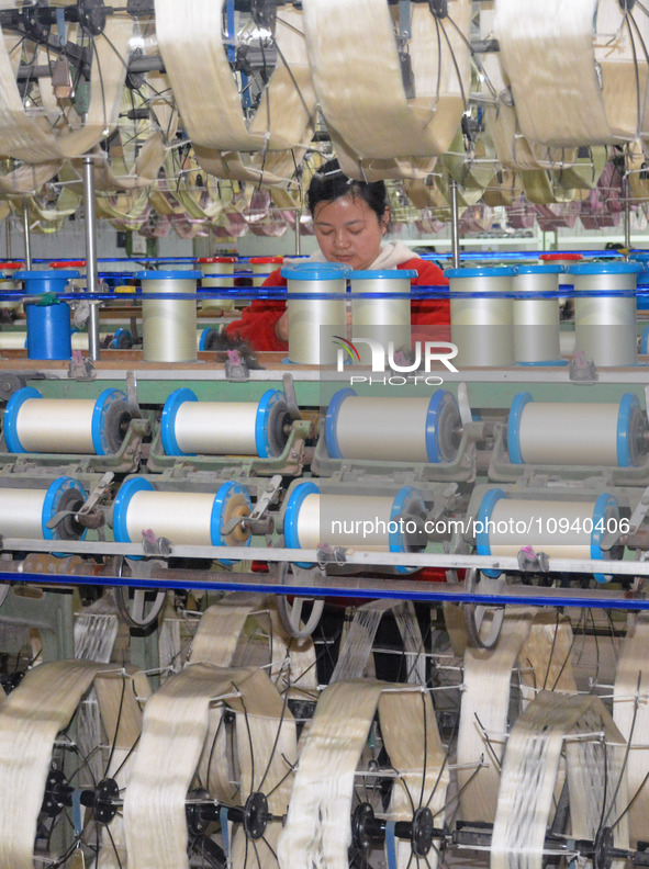 A worker is making silk products on a production line at a workshop of a silk production enterprise in Anqing, China, on January 26, 2024. 