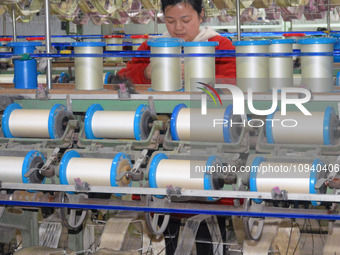 A worker is making silk products on a production line at a workshop of a silk production enterprise in Anqing, China, on January 26, 2024. (