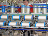 A worker is making silk products on a production line at a workshop of a silk production enterprise in Anqing, China, on January 26, 2024. (