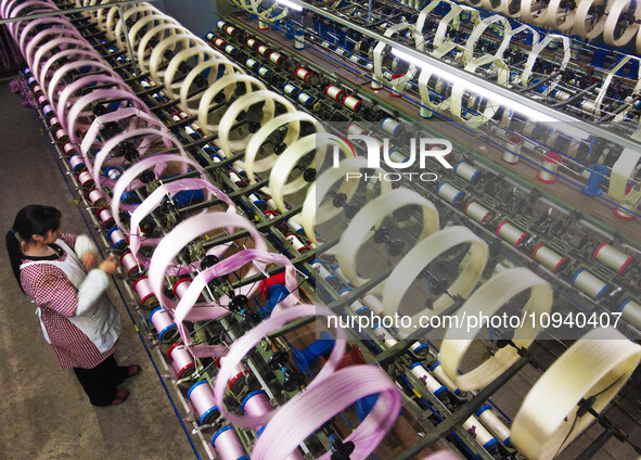 A worker is making silk products on a production line at a workshop of a silk production enterprise in Anqing, China, on January 26, 2024. 