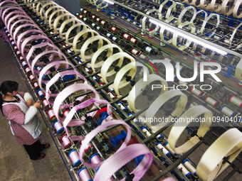 A worker is making silk products on a production line at a workshop of a silk production enterprise in Anqing, China, on January 26, 2024. (